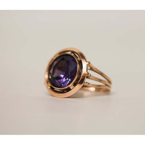 623 - A single stone ring, the circular colour change spinel within collet setting on a rose gold band, in... 