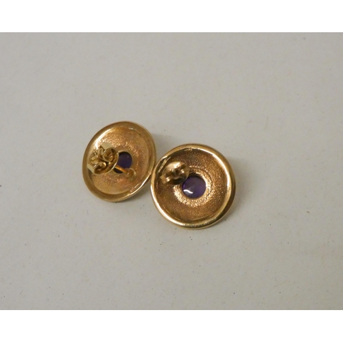 613 - A pair of amethyst and gold circular shield shaped pierced earrings, hallmarked 9ct gold. Gross weig... 