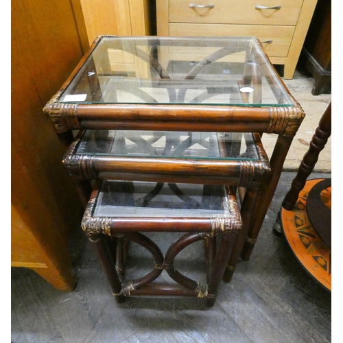 117 - A nest of three bamboo coffee tables with glass tops