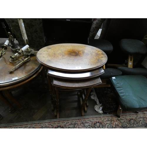 61 - A nest of three oval walnut coffee table on fine turned legs