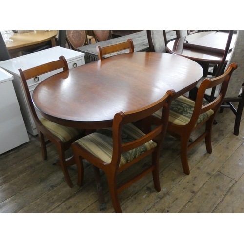 61 - An oval Georgian style yewood extending dining table with fold away centre leaf together with four m... 