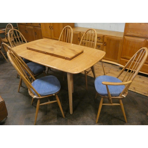 121 - An Ercol Blonde Elm Windsor grand dining table with two centre leaves and eight matching spindle bac... 