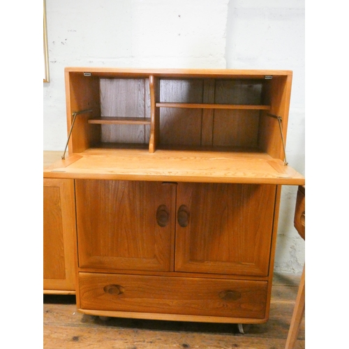 127 - An Ercol Blonde Elm Windsor bureau with cupboards and drawer under. 32 1/2