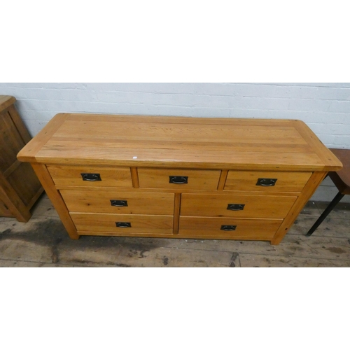 2 - A good quality light oak sideboard style chest of seven assorted drawers with iron handles. 5' wide...