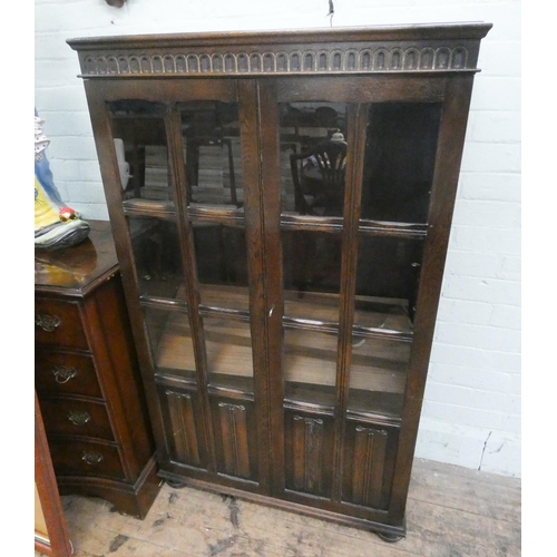 36 - A reproduction oak glazed two door book case with inner fold panels. 32