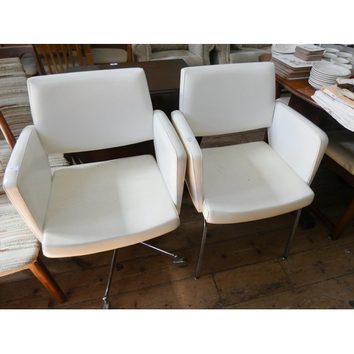 58 - A revolving office elbow chair in cream leather and a similar standard elbow chair