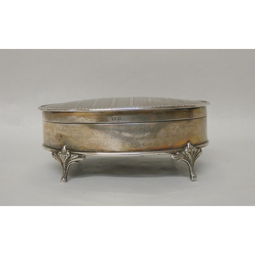 550 - A large oval hallmarked silver dressing table trinket box, the hinged lid with engine turned decorat... 