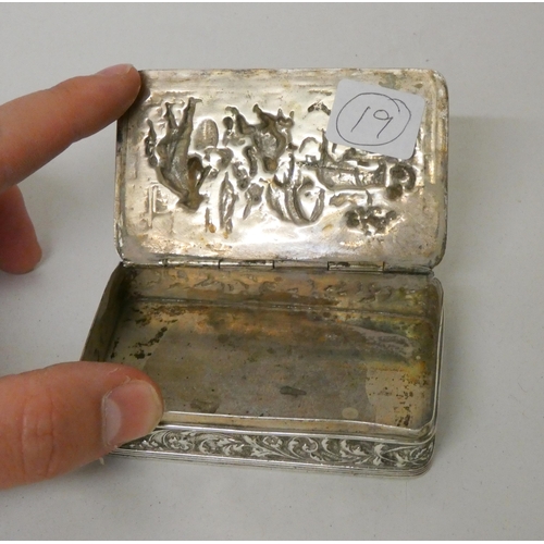 554 - A Dutch silver snuff box of rectangular form, the hinged lid embossed with village scene. Diameter 8... 