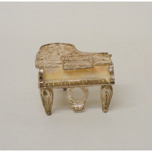 576 - A miniature silver filigree trinket box in the form of a grand piano. 5cm across.