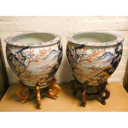 198 - A pair of decorative Chinese fish bowls on wooden stands. Each 15