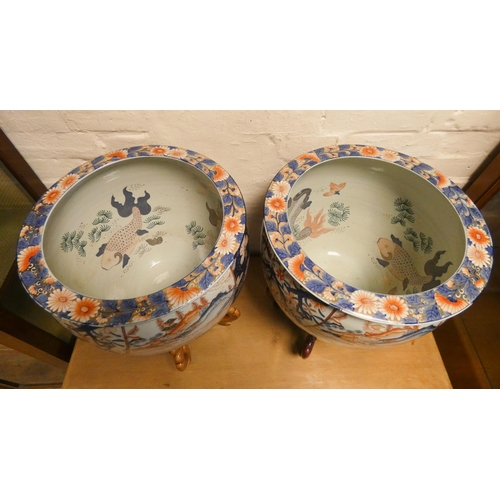 198 - A pair of decorative Chinese fish bowls on wooden stands. Each 15