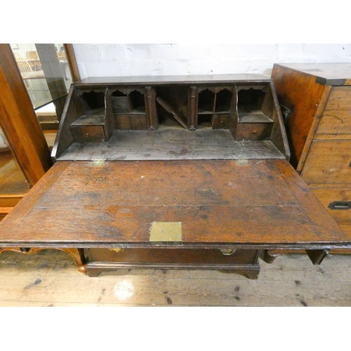 301 - A Georgian oak bureau. The fall flap with fitted interior above three long drawers. 36