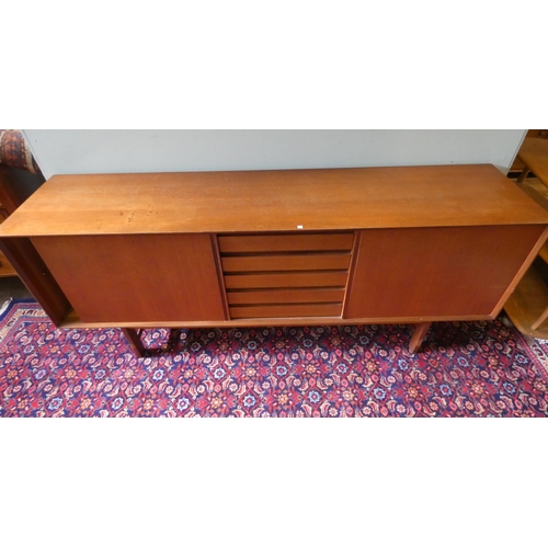 379 - A 1970's long low teak sideboard with sliding doors and five centre drawers 6'3