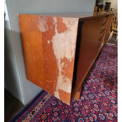 379 - A 1970's long low teak sideboard with sliding doors and five centre drawers 6'3