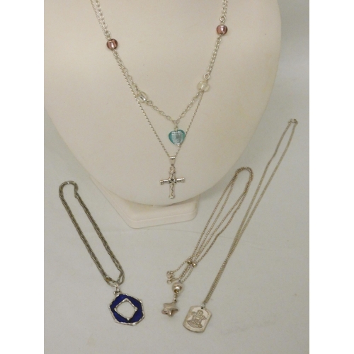 604 - A collection of five silver pendants and necklaces.