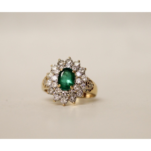 680 - An emerald and diamond oval cluster ring. The claw set emerald surrounded by two rows of brilliant c... 