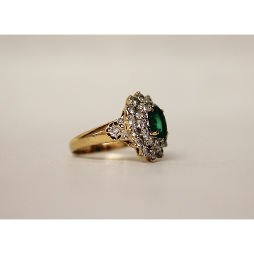 680 - An emerald and diamond oval cluster ring. The claw set emerald surrounded by two rows of brilliant c... 