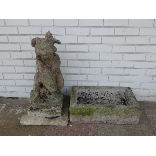 934 - A large figure of a child carrying a fish in reconstituted stone and reconstituted stone trough