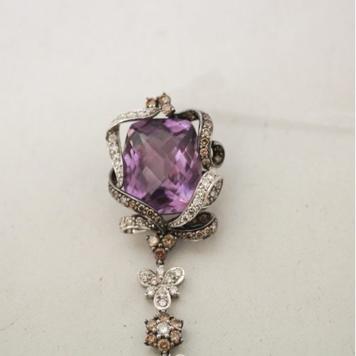 671 - A large modern amethyst and diamond pendant comprising two large mixed facet amethyst in a floral mo... 