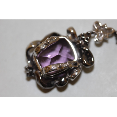 671 - A large modern amethyst and diamond pendant comprising two large mixed facet amethyst in a floral mo... 