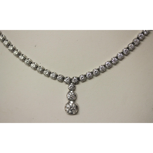 675 - A modern diamond necklace comprising brilliant cut diamonds in a line with a central three diamond d... 