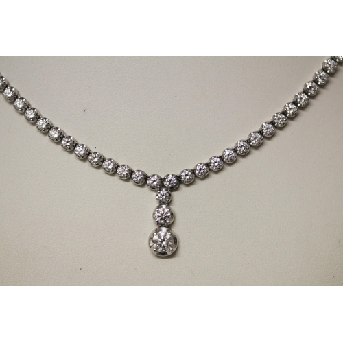 675 - A modern diamond necklace comprising brilliant cut diamonds in a line with a central three diamond d... 