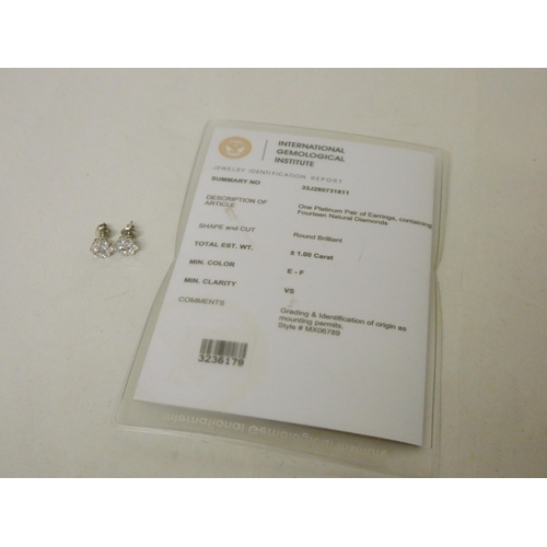 676 - A pair of platinum and diamond ear studs set in a diamond daisy design in platinum with safety screw... 