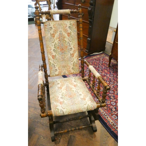 447 - An oak framed American rocking elbow chair, with tapestry upholstered seat, back and arm pads