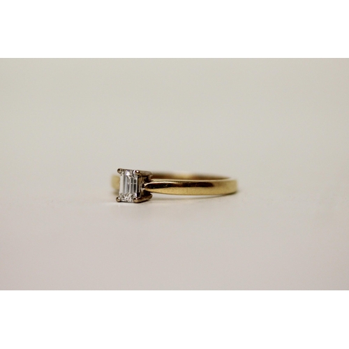 662 - A modern emerald cut solitaire diamond engagement ring, on 18ct yellow gold band. Hallmarked, diamon... 