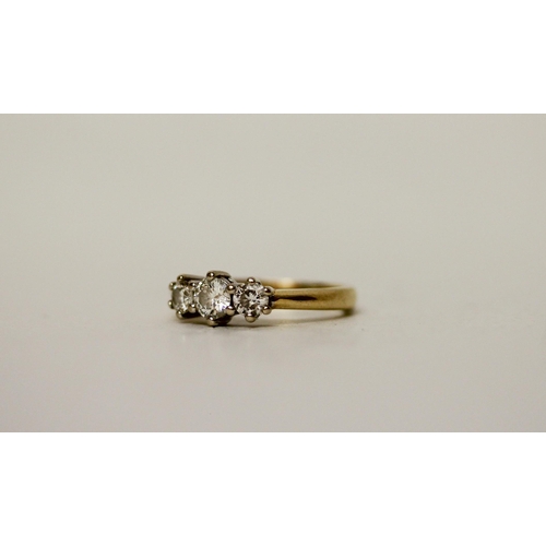 663 - A three stone diamond ring, on 18ct gold band, diamond weight 0.5 carat marked in band. Ring size H,... 