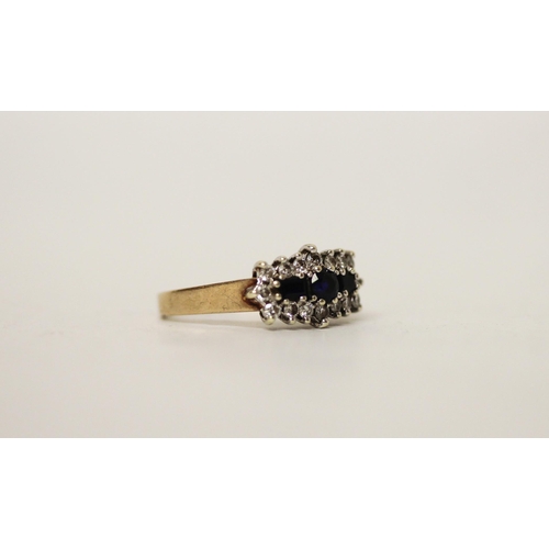 665 - A three stone sapphire and diamond cluster panel ring, on hallmarked 9ct yellow gold band. Ring size... 