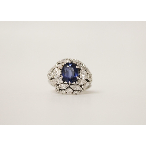 677 - A mid 20th century sapphire and diamond bombé ring, with an oval mixed cut sapphire claw set within ... 