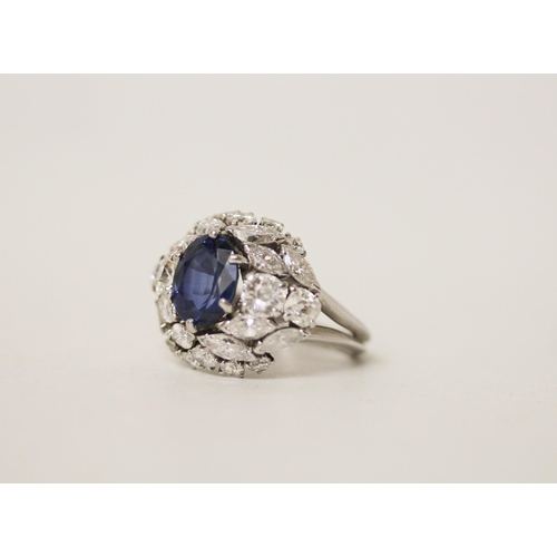 677 - A mid 20th century sapphire and diamond bombé ring, with an oval mixed cut sapphire claw set within ... 