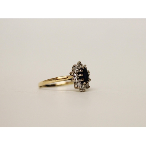 693 - A sapphire and diamond oval cluster ring, on 18ct yellow gold band. Ring size K, gross weight 2.8g