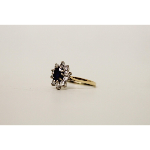 693 - A sapphire and diamond oval cluster ring, on 18ct yellow gold band. Ring size K, gross weight 2.8g