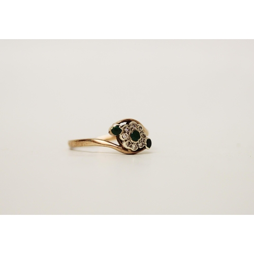 702 - A 9ct emerald and diamond cluster ring in a cross over setting. Hallmarked band, ring size R, gross ... 