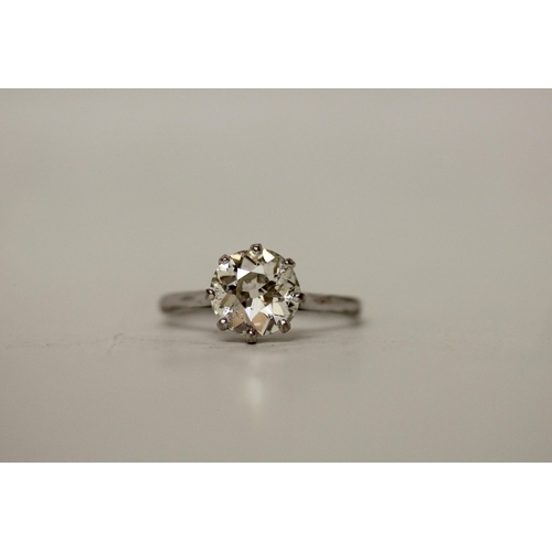 705 - A 20th century diamond solitaire ring, the old cut circular diamond with white metal claws leading t... 