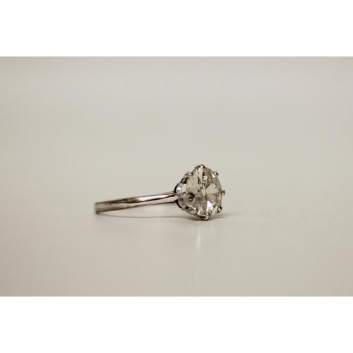 705 - A 20th century diamond solitaire ring, the old cut circular diamond with white metal claws leading t... 