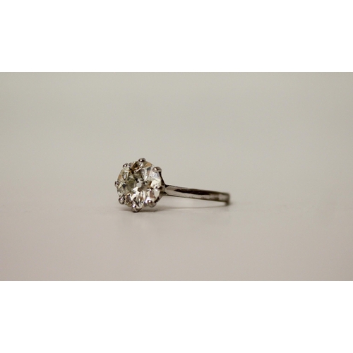 705 - A 20th century diamond solitaire ring, the old cut circular diamond with white metal claws leading t... 