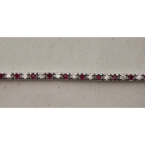 706 - A modern 9ct white gold ruby and diamond line bracelet. Hallmarked to the clasp, gross weight 5.5g, ... 