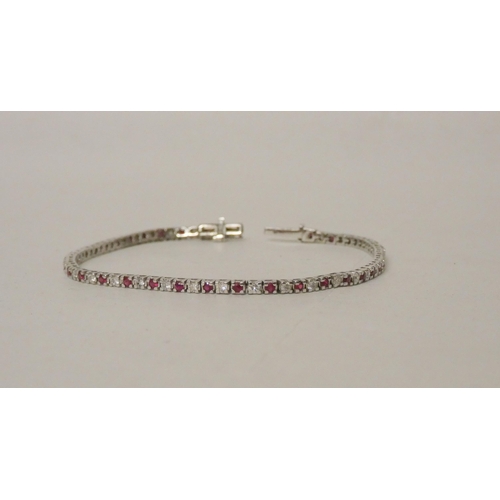 706 - A modern 9ct white gold ruby and diamond line bracelet. Hallmarked to the clasp, gross weight 5.5g, ... 