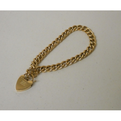 721 - A 9ct gold curb chain bracelet with heart shaped padlock fastening and safety chain, hallmarked. Gro... 