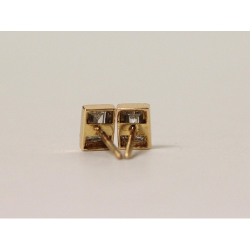 731 - A pair of diamond ear studs, each set with an emerald cut diamond in rectangular collet setting to s... 