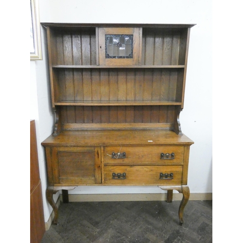 17 - A 1920's Art Nouveau style oak dresser with shelf and leaded cabinet back, two drawers and cupboard ... 