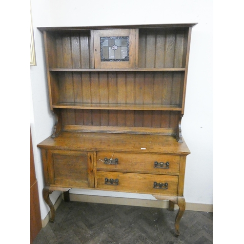 17 - A 1920's Art Nouveau style oak dresser with shelf and leaded cabinet back, two drawers and cupboard ... 