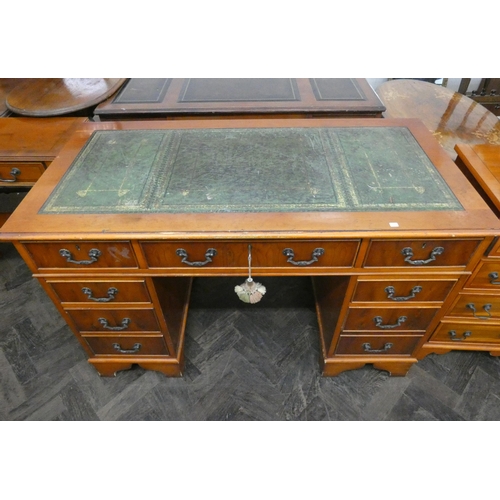 73 - A Georgian style yew wood pedestal office desk fitted nine drawers with green leather top. 4' wide