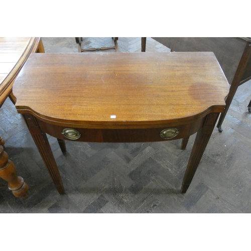 80 - A Georgian style shaped front mahogany folding top tea table on reeded legs, fitted one drawer