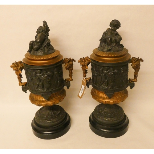 203 - A pair of French bronze and gilt metal mounted urns. The lids with cherub finials. Each standing 42c... 