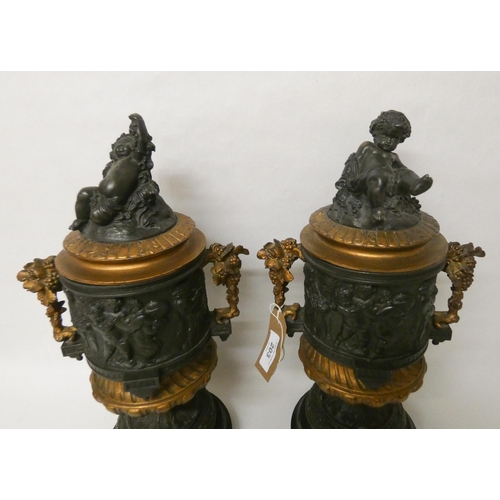 203 - A pair of French bronze and gilt metal mounted urns. The lids with cherub finials. Each standing 42c... 