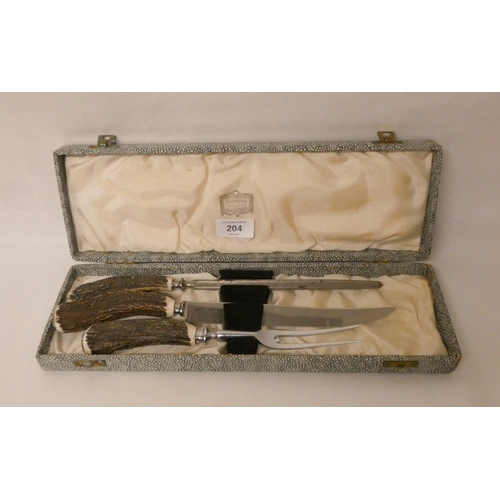 204 - A country house antler mounted carving set retailed by Harrods in a fitted box